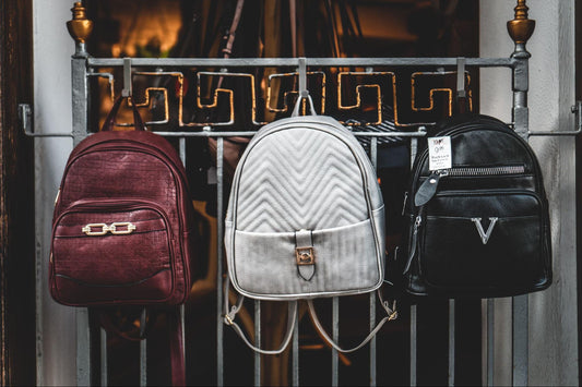 three custom print-on-demand backpacks hanged on a rail