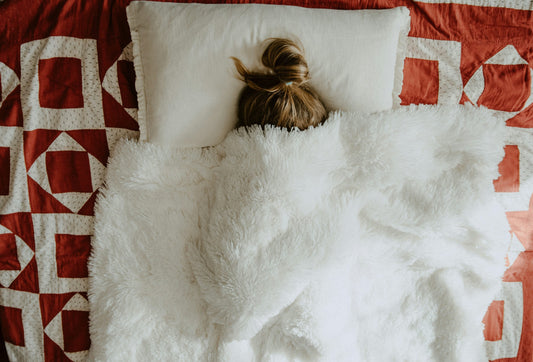 girl sleeping under white blanket