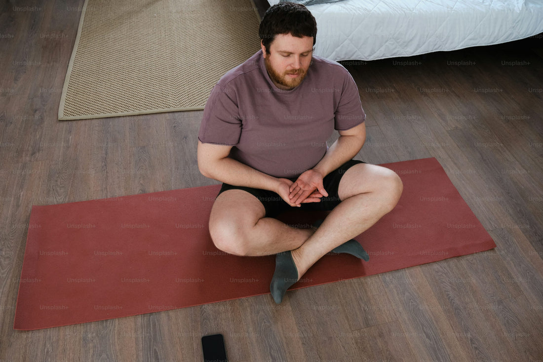 man meditating on top of a red yoga mat